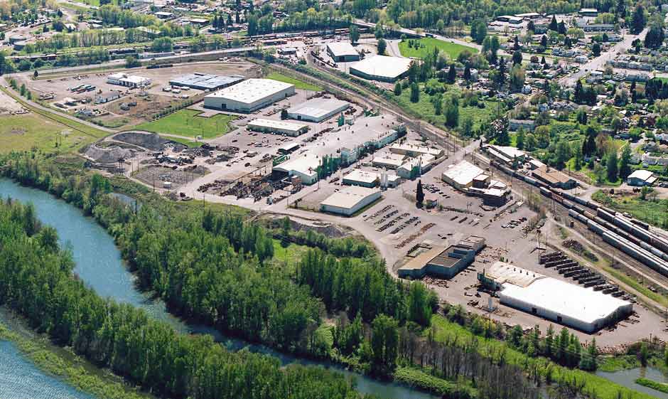 Aerial photo of Columbia Steel, with a view of Portland's St. Johns neighborhood in the upper right, and the Columbia Slough wetlands in the foreground.