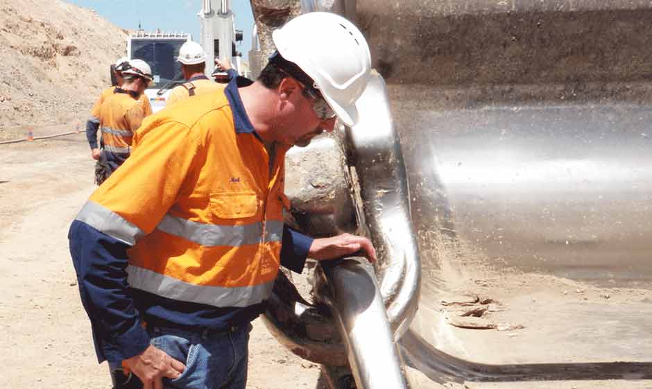 Columbia Steel field representative examines a customer's dragline chain in Australia
