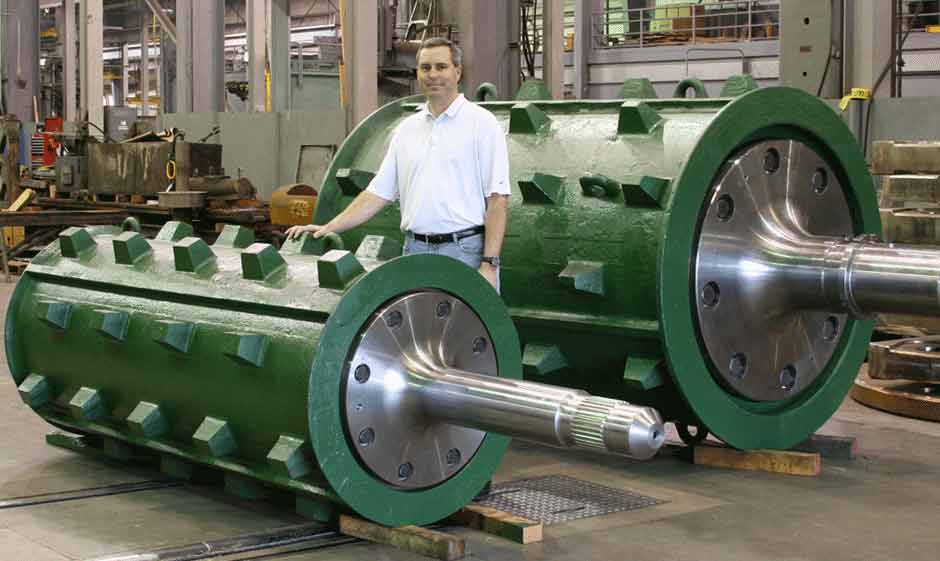 Greg Stegmaier, standing next to two shredder feed rolls, retires from Columbia Steel