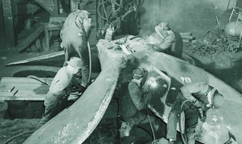 Columbia employees finish a steel propeller during WWII.
